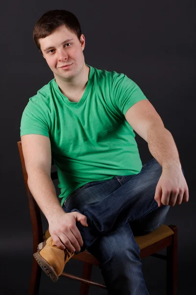 A young man sitting on a chair Stock Image