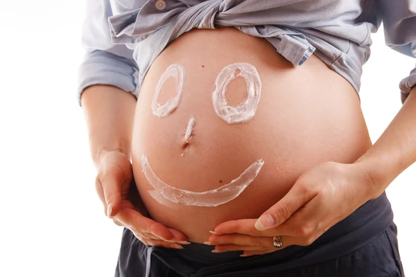 Abdomen una joven embarazada con una cara sonriente Imágenes de stock libres de derechos