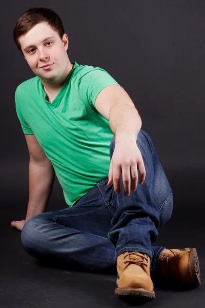 A young man sitting on the floor Stock Picture