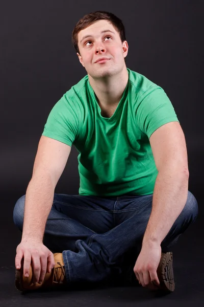 A young man sitting on the floor Stock Picture