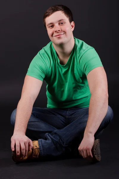 A young man sitting on the floor Stock Image