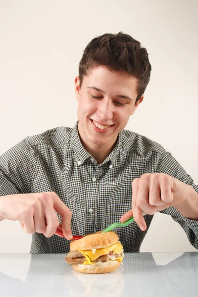 Člověk jíst hamburger — Stock fotografie