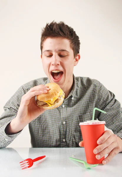 Hombre comiendo hamburguesa Imágenes De Stock Sin Royalties Gratis