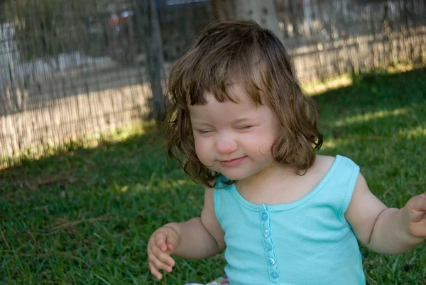 The baby girl sitting on the green meado — Stock Photo, Image