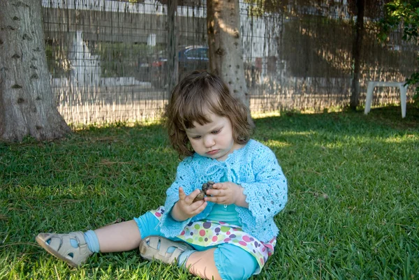 The baby girl sitting on the green meado — Stock Photo, Image