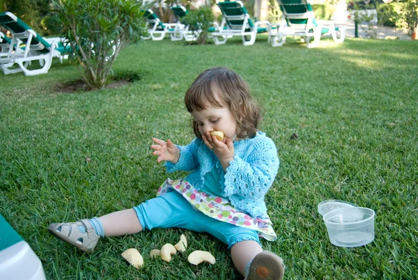 La bambina sta mangiando la mela. — Foto Stock