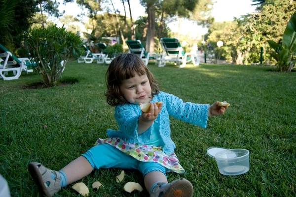 The baby girl is eating apple — Stock Photo, Image