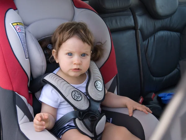 La petite fille assis en toute sécurité dans sa voiture mer — Photo