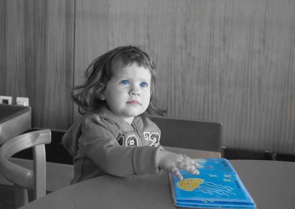 La bambina sta cercando un libro. — Foto Stock