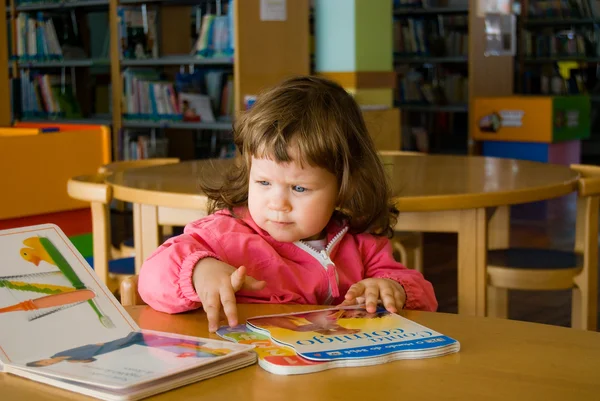 A menina está procurando livro — Fotografia de Stock