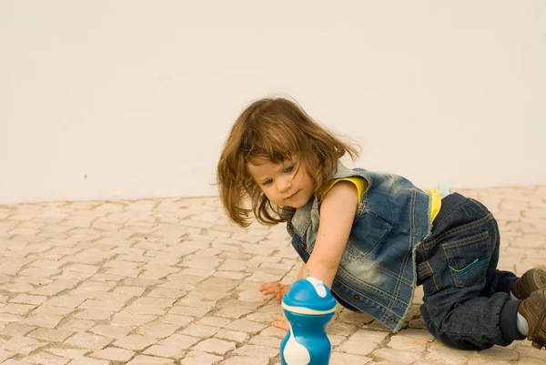 Маленькая девочка играет на булыжнике — стоковое фото