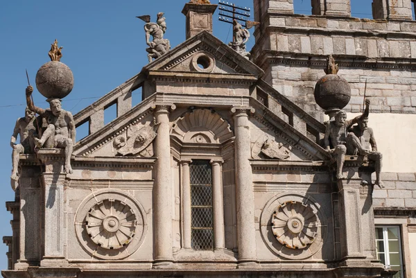 Kyrkans fasad med muskulös siffror stödja glober. — Stockfoto