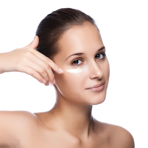 Portrait of beautiful woman applying cream on face - isolated on — Stock Photo, Image