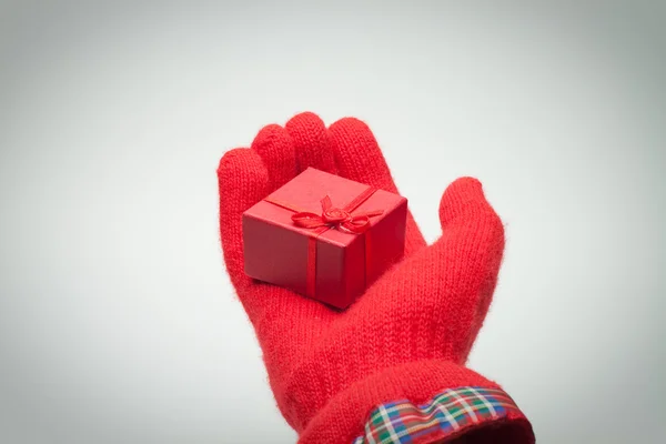 Caja roja de mano con regalo sobre gris —  Fotos de Stock