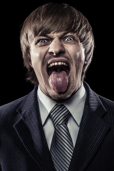 Jovem empresário gritando com a língua estendida — Fotografia de Stock