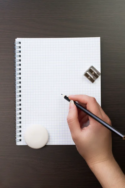 Mulher escrevendo com lápis no caderno no escritório — Fotografia de Stock