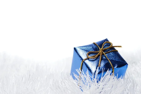 Blue present box over the white tinsel background — Stock Photo, Image