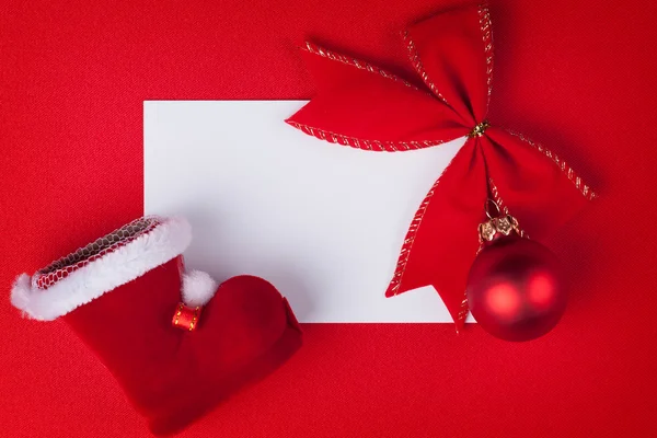 Grußkarte und Weihnachtsdekoration auf rotem Hintergrund — Stockfoto