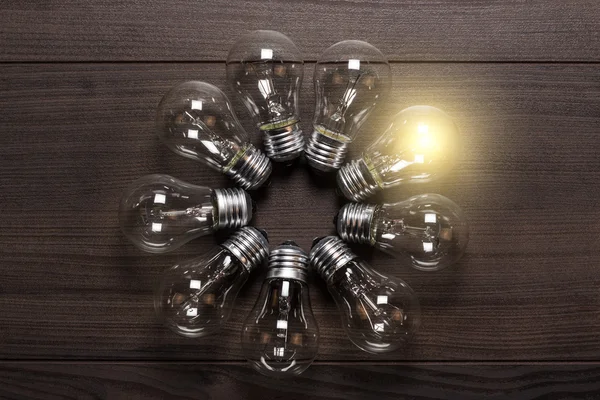 ahşap arka plan benzersiz kavramı üzerinde parlayan ampul