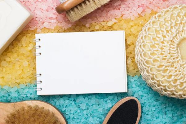 Acessórios de banho e bloco de notas em branco sobre sal marinho colorido — Fotografia de Stock