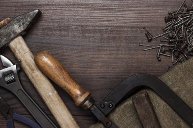 ahşap arka plan üzerinde paslanmış İnşaat aletleri