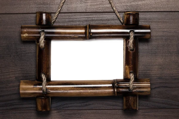 Empty frame with copy space hanging on wooden wall