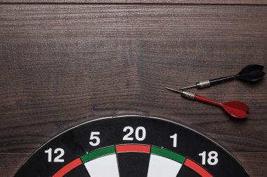 hedef ve kahverengi ahşap masa üstünde iki Dart