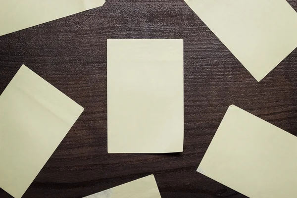 Adesivos em branco na mesa de madeira marrom — Fotografia de Stock