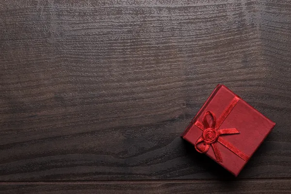 Red present box over wooden background — Stock Photo, Image