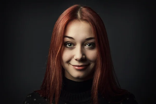 Junge Frau vor dunkelgrauem Hintergrund — Stockfoto
