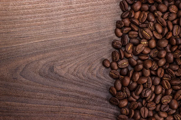 Chicchi di caffè su sfondo marrone in legno — Foto Stock