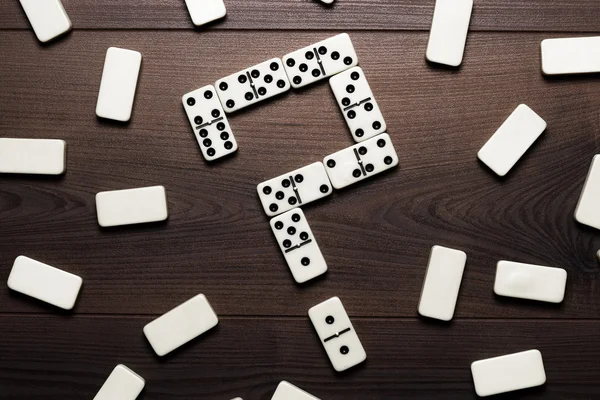 Piezas de dominó formando signo de interrogación en mesa de madera — Foto de Stock