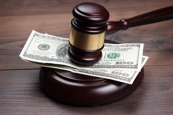 Richtergabel und Geld auf braunem Holztisch — Stockfoto