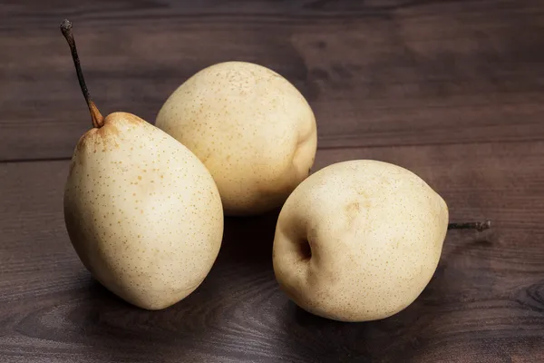 Three fresh pears on wooden table — Stock Photo, Image