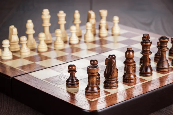 Tablero de ajedrez con figuras sobre mesa de madera — Foto de Stock
