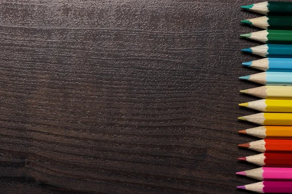 暗棕色的桌子背景上的彩色铅笔 — 图库照片