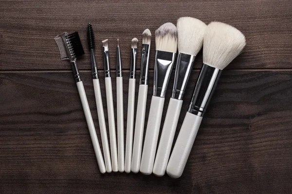 White make-up brushes on wooden table — Stock Photo, Image
