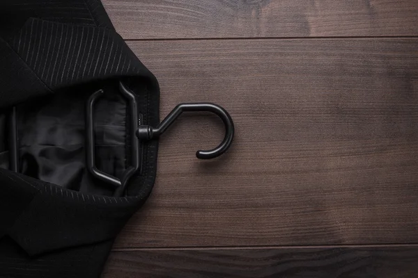 木製の背景に黒のスーツ — ストック写真