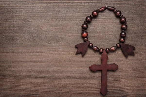 Cruz de madera sobre fondo de mesa marrón — Foto de Stock