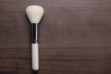 kahverengi masa üzerinde beyaz makyaj fırçası