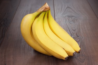 Fresh bananas on the brown table clipart
