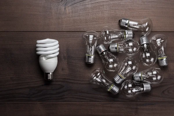 Bulb uniqueness concept on the wooden table — Stock Photo, Image