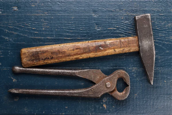 Zange und Hammer auf blauem Tisch — Stockfoto