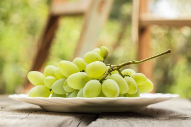 Beyaz plaka üzerinde Yeşil üzüm demet