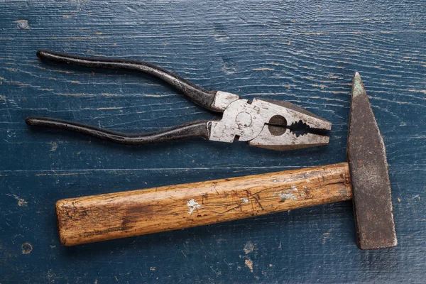 Pliers and hammer on blue table — Stock Photo, Image