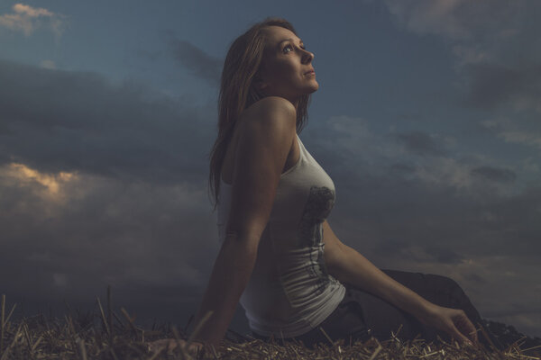 Beautiful girl sitting on haystack