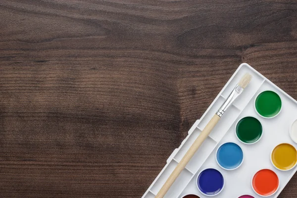 Palette with paint and brush on the table — Stock Photo, Image