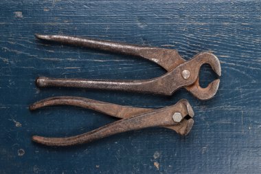 Mavi masa üzerinde eski paslı maşa