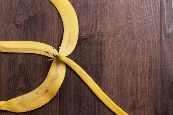 Bananenschil op de houten achtergrond — Stockfoto