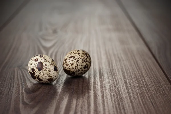 Křepelčí vejce na hnědý dřevěný stůl — Stock fotografie